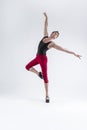 Ballet Ideas. Contemporary Ballet of Flexible Athletic Man Posing in Red Tights in Ballanced Dance Pose With Hands Lifted in