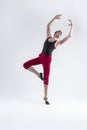 Ballet Ideas. Modern Ballet of Flexible Athletic Man Posing in Red Tights in Ballanced Dance Pose With Hands Lifted in Studio on