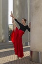 Ballet Ideas. Professional Ballet Dancer in Red Tutu Dress Posing in Red Skirt in Stretching Dance Pose With Lifted Hands and