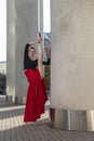 Ballet Ideas. Professional Ballet Dancer in Red Tutu Dress Posing in Red Skirt in Stretching Dance Pose With Lifted Hands and