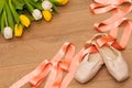 Ballet pointe shoes and tulips on wooden background Royalty Free Stock Photo