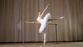 ballet rehearsal, in old theater hall. Young ballerina in white ballet skirt, tutu, is engaged at ballet, performs