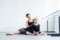 ballet teacher and little student in black clothing exercising together