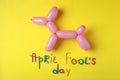 Balloon animal and phrase APRIL FOOL`S DAY on background, flat lay