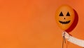 Balloon with drawing face in woman hand on orange Royalty Free Stock Photo