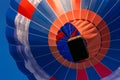 Balloon flying high in the sky. Aerostat close-up view from below. Balloon basket. Aeronautic sport. Burning gas. Bright multi- Royalty Free Stock Photo