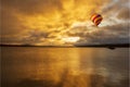 A balloon flying over a lake in a beautiful sunrise Royalty Free Stock Photo