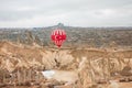 Balloon over rocky landscape of Cappadocia Valley at cloudy weather