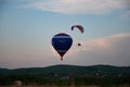 Balloon and paraglider in the evening sky.