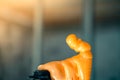 A balloon with polyurethane foam skips. Construction adhesive foam in bright orange close-up on a blurred background. Universal