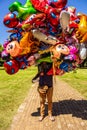 The balloon seller in a park.