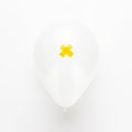 Balloon with yellow cross on it over white background