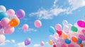 Balloons of all sizes soaring against a blue sky, forming a backdrop for an open-air birthday party