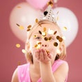Balloons, birthday and girl with confetti on pink background for party, celebration and special day. Happy, excited and Royalty Free Stock Photo