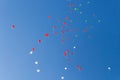 Balloons. The children released a lot of balls with ropes in the sky.Red and green balloons in the blue sky in the rays of the sun Royalty Free Stock Photo