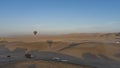 Balloons are flying over the desert. Shadows on the sand. Royalty Free Stock Photo