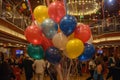 balloons and streamers decorating ships main hall, people mingling