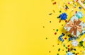 Balloons and various party decorations on a yellow background with copy space. Birthday background top view