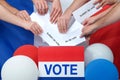 Hands placing ballots into box with french flag in background Royalty Free Stock Photo