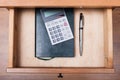 Ballpen, calculator and notebook in open drawer Royalty Free Stock Photo