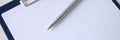 Ballpoint pen lying on clipboard with blank document closeup Royalty Free Stock Photo