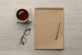 Ballpoint pen, notebook and cup of tea on wooden table, flat lay Royalty Free Stock Photo