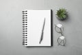 Ballpoint pen, notebook and glasses on light gray table, flat lay Royalty Free Stock Photo