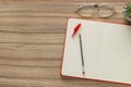 Ballpoint pen, notebook and glasses on wooden table, flat lay. Space for text Royalty Free Stock Photo