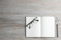 Ballpoint pen, notebook and glasses on wooden table, flat lay. Space for text Royalty Free Stock Photo