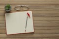 Ballpoint pen, notebook and glasses on wooden table, flat lay. Space for text Royalty Free Stock Photo