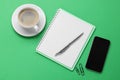 Ballpoint pen, notebook and smartphone on green background, flat lay Royalty Free Stock Photo