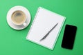 Ballpoint pen, notebook and smartphone on green background, flat lay Royalty Free Stock Photo