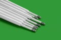 Ballpoint pen refills. Plastic refills for ballpoint pens. Copy space. Pile of white ink refills on a green Royalty Free Stock Photo