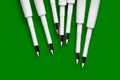 Ballpoint pen refills. Plastic refills for ballpoint pens. Row of white ink refills on a green Royalty Free Stock Photo