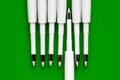 Ballpoint pen refills. Plastic rods for a ballpoint pen. Row of white ink refills on a green Royalty Free Stock Photo