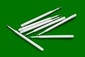 Ballpoint pen refills. Plastic rods for a ballpoint pen. Stack of white ink refills on a green Royalty Free Stock Photo