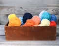 Balls of bright woolen yarn in a wooden box on old wood wall background Royalty Free Stock Photo