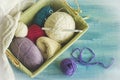 Balls of colored thread lying in a rectangular basket.