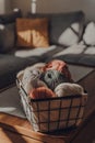 Balls of earth coloured yarn in a basket within  apartment interior, selective focus Royalty Free Stock Photo