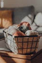 Balls of earth coloured yarn in a basket within  apartment interior, selective focus Royalty Free Stock Photo