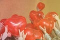 Balls in the form of hearts in children`s hands, toned photo