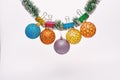 Balls with ornaments hang on shimmering green tinsel. Christmas ornaments concept. Tinsel with pinned christmas