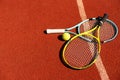 Balls and racket are lying on clay brown professional tennis court Close up of tennis balls and racket on dross at Royalty Free Stock Photo