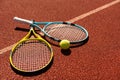 Balls and racket are lying on clay brown professional tennis court Close up of tennis balls and racket on dross at Royalty Free Stock Photo