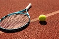 Balls and racket are lying on clay brown professional tennis court Close up of tennis balls and racket on dross at Royalty Free Stock Photo