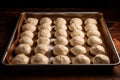 Balls of raw dough in a baking tray