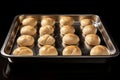 Balls of raw dough in a baking tray