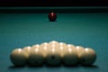 Balls for Russian Billiards are lined with a pyramid at the beginning of the game. white balls on a green table. serious sport,