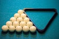 Balls for Russian Billiards are lined with a pyramid at the beginning of the game. white balls on a green table. serious sport,