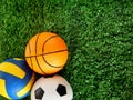 Balls for soccer, basketball and volleyball are lying on the green grass. Royalty Free Stock Photo